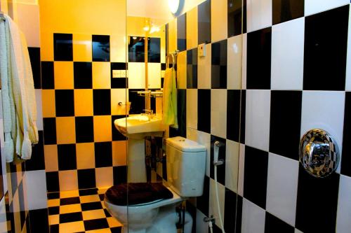 a bathroom with a black and white checkered wall at Villa Rosa in Kandy
