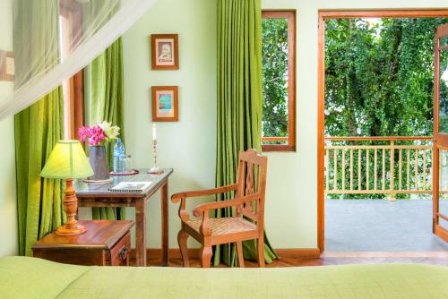 a bedroom with a desk and a chair and a window at Villa Rosa in Kandy