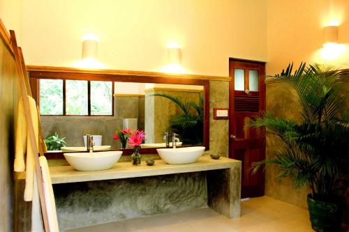 a bathroom with two sinks and a large mirror at Villa Rosa in Kandy