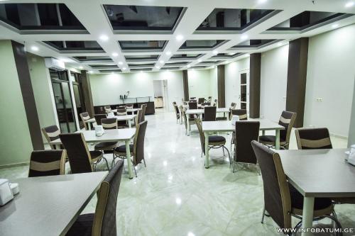 a dining room with tables and chairs and a classroom at Hotel Wave in Batumi