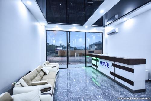 a living room with a couch and a table and glass doors at Hotel Wave in Batumi