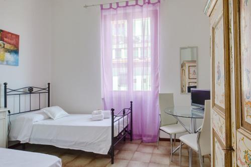 a bedroom with a bed and a table and a window at Sette Note Guest House in Arezzo