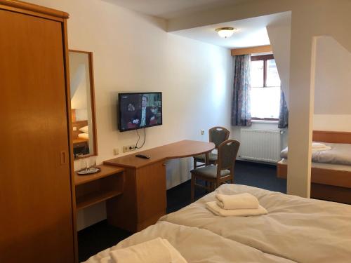 a hotel room with a bed and a desk at Ennstalerhof in Grossraming