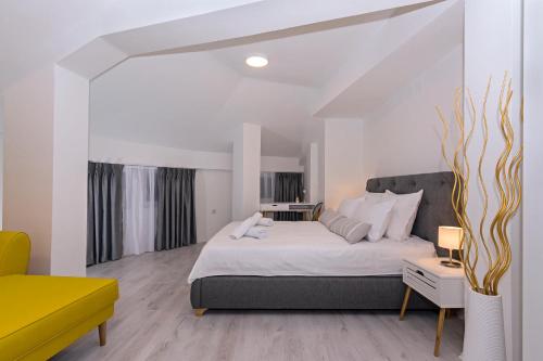 a bedroom with a large bed and a yellow chair at Casa di VaLL in Ohrid