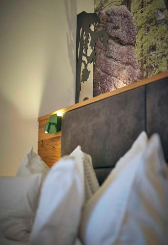 a bed with white pillows and a picture on the wall at Hotel Lindenhof in Kellberg