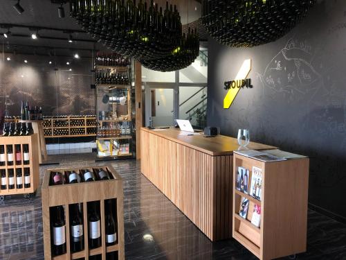 a wine shop with a counter with bottles of wine at Rodinné Vinařství Skoupil in Velké Bílovice