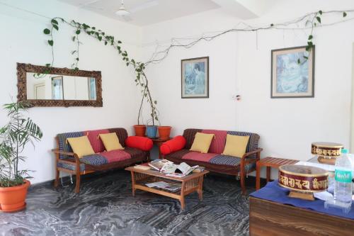 a living room with two couches and a table at Zhim Zhim Guest House in Bīr