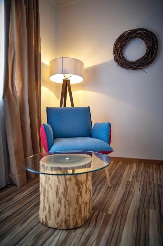 a living room with a blue couch and a table at Hotel Lindenhof in Kellberg