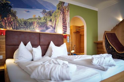 a bedroom with a large bed with a painting on the wall at Hotel Lindenhof in Kellberg