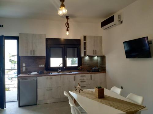 a kitchen with a table and chairs and a kitchen with a sink at Home Sweet Home in Ammoudia