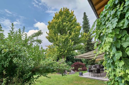 a garden with a table and chairs and trees at Hotel Lindenhof in Kellberg