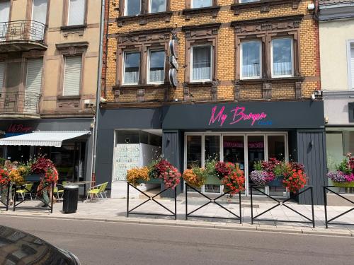 un bâtiment avec des fleurs devant un magasin dans l'établissement L'Acacia, à Forbach