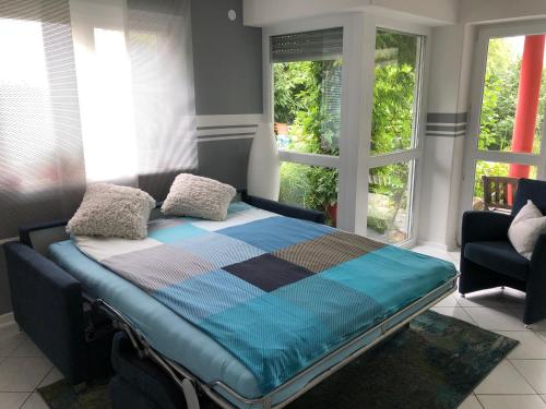 ein Schlafzimmer mit einem Bett in einem Zimmer mit Fenstern in der Unterkunft Apartment Green Elephant in Tettnang