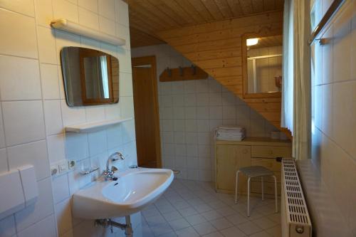 ein Badezimmer mit einem Waschbecken und einer Treppe in der Unterkunft Haus Waldblick in Weissensee