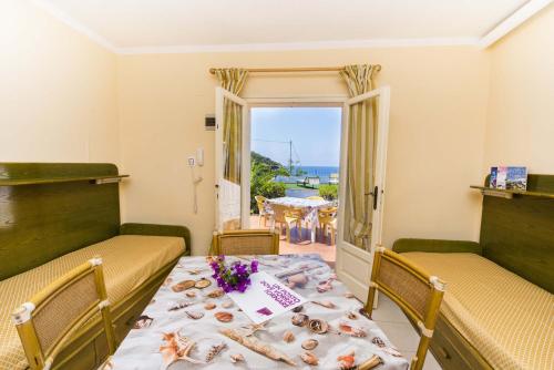 una sala da pranzo con tavolo e vista sull'oceano di Residential Hotel Villaggio Innamorata a Capoliveri
