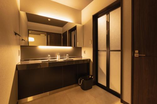 La salle de bains est pourvue d'un lavabo et d'un miroir. dans l'établissement BEPPU RIKYU, à Beppu