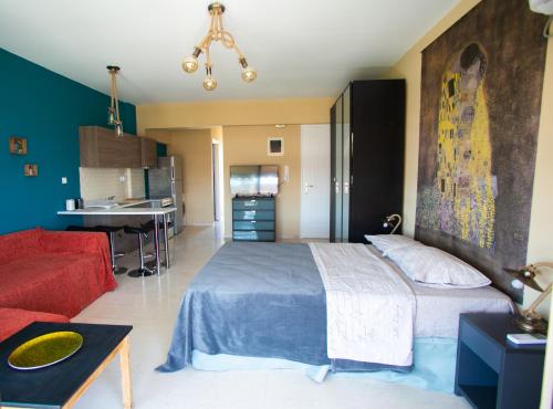 a bedroom with a large bed and a red couch at Joanna's studio (Rafina port) in Rafina