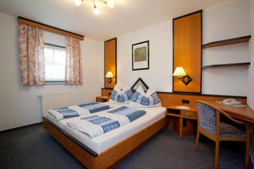 a hotel room with a bed and a desk and a desk at Seevilla Nina in Maria Wörth