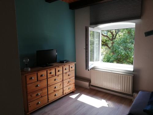 a bedroom with a dresser with a television and a window at FW Achterdeck, 1 Obergeschoss, Petershof-Lehbek in Gelting