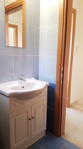 a bathroom with a white sink and a mirror at Lovely holiday home,Kapparis,2 swimming pools,Wifi in Paralimni