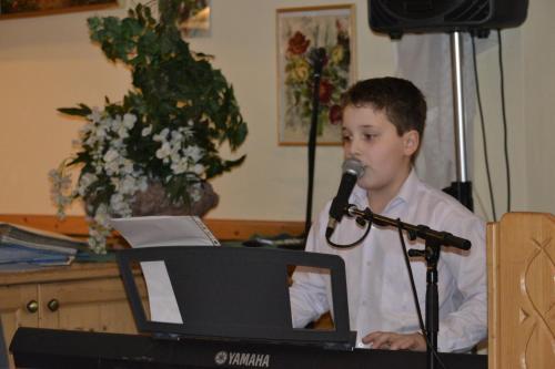 a boy singing into a microphone next to a computer at Ennstalerhof in Grossraming