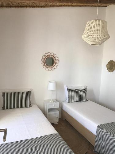 two twin beds in a room with a mirror at Casas de Mértola - N. Sª das Neves in Mértola