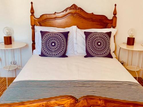 a bed with purple and white pillows on it at Casas de Mértola - N. Sª das Neves in Mértola