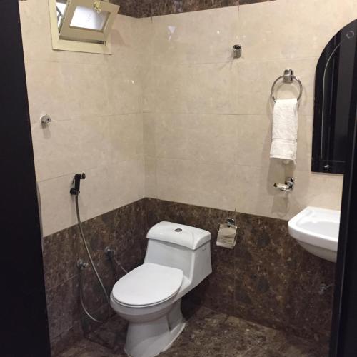 a bathroom with a toilet and a sink at شقق منازل الدانة للشقق المخدومة in Abha