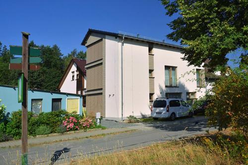 a white van parked in a parking lot next to a building at Ferienwohnung Sonne in Kurort Gohrisch