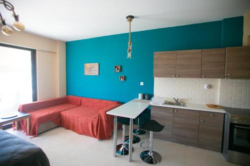 uma sala de estar com um sofá vermelho e uma cozinha em Joanna's studio (Rafina port) em Rafina
