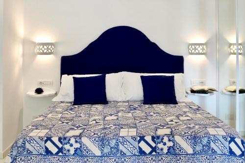 a bedroom with a bed with a blue and white quilt at Gema Suites in Positano