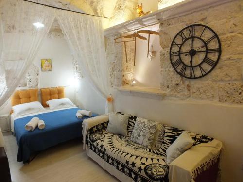 ein Schlafzimmer mit einem Bett und einer Uhr an der Wand in der Unterkunft Casa Cuore di Pietra "STONEHEART HOME" in Ceglie Messapica