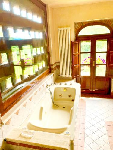 a large bathroom with a tub and a window at B&B La Fornace del Sole in Capannori