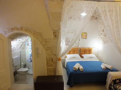 1 Schlafzimmer mit einem blauen Bett und einem Badezimmer in der Unterkunft Casa Cuore di Pietra "STONEHEART HOME" in Ceglie Messapica