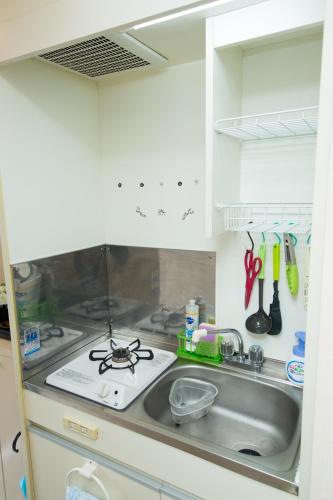 a kitchen with a sink and a stove at Cozyhouse 211 free wifi a rented electric bicycle in Kyoto