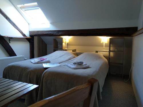 a hotel room with two beds with towels on them at La Fermette Blanche in Nadrin