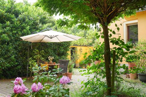 a patio with an umbrella and a table with flowers at Biggi‘s Bed&Breakfast in Flonheim