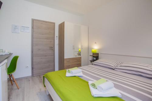 a bedroom with a large bed with towels on it at Room Elelina in Cres