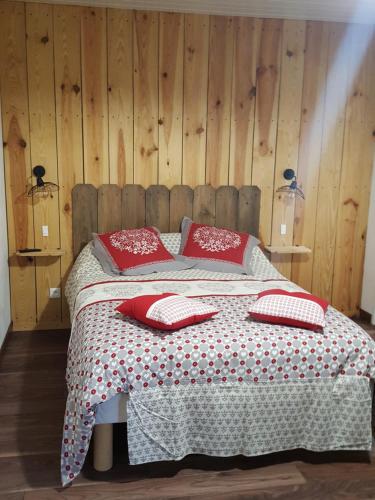 Un dormitorio con una cama con almohadas rojas. en Chez Alexandra, en Louchats