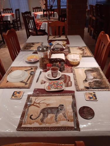 a long table with plates and dishes on it at Tismaree Guestfarm in Rietoog