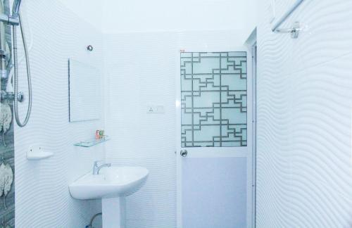 a white bathroom with a sink and a shower at Lavender Home Yala Safari in Tissamaharama