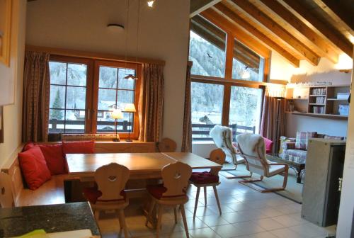 eine Küche und ein Wohnzimmer mit einem Tisch und Stühlen in der Unterkunft Chalet Christitia in Saas-Grund