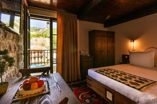 a bedroom with a bed and a table with fruit on it at Stara Čaršija Hotel & SPA in Bar