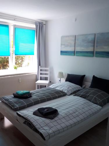 a bedroom with two beds and a chair and windows at Sportpension "Seminarhaus an der Eider" in Tönning