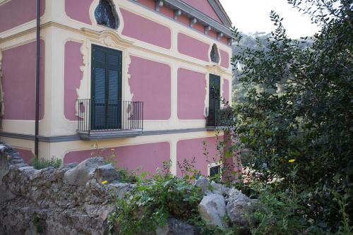 a pink building with two windows and a stone wall at PALAZZO PELLEGRINO vietri in Vietri sul Mare