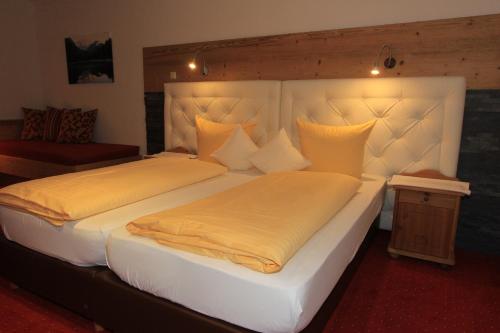a bedroom with two beds with yellow pillows at Landhaus Lechthaler in Sankt Anton am Arlberg