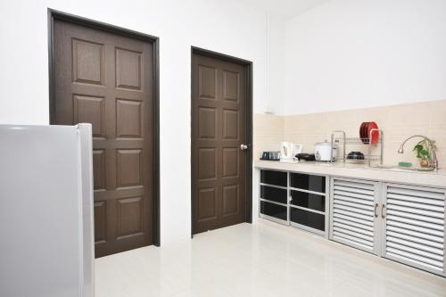 a kitchen with two brown doors and a counter at Ada Hotel & Apartment in Kuala Terengganu