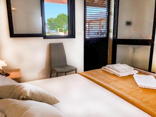 a bedroom with a bed and a chair and windows at Il mondo dei sogni in Porto Cesareo