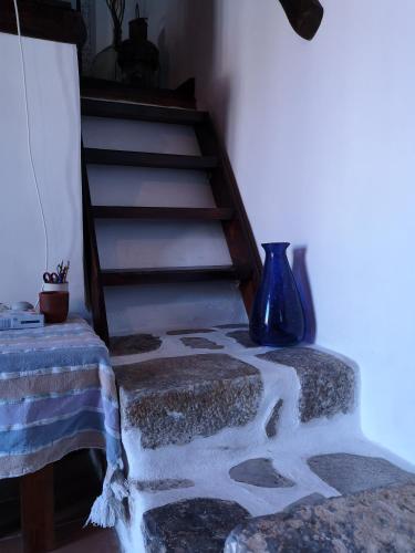 a staircase with a blue vase sitting next to a table at Glaros in Pera Gyalos