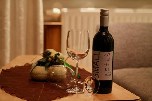 a bottle of wine and a glass on a table at Appartment Leni in Längenfeld